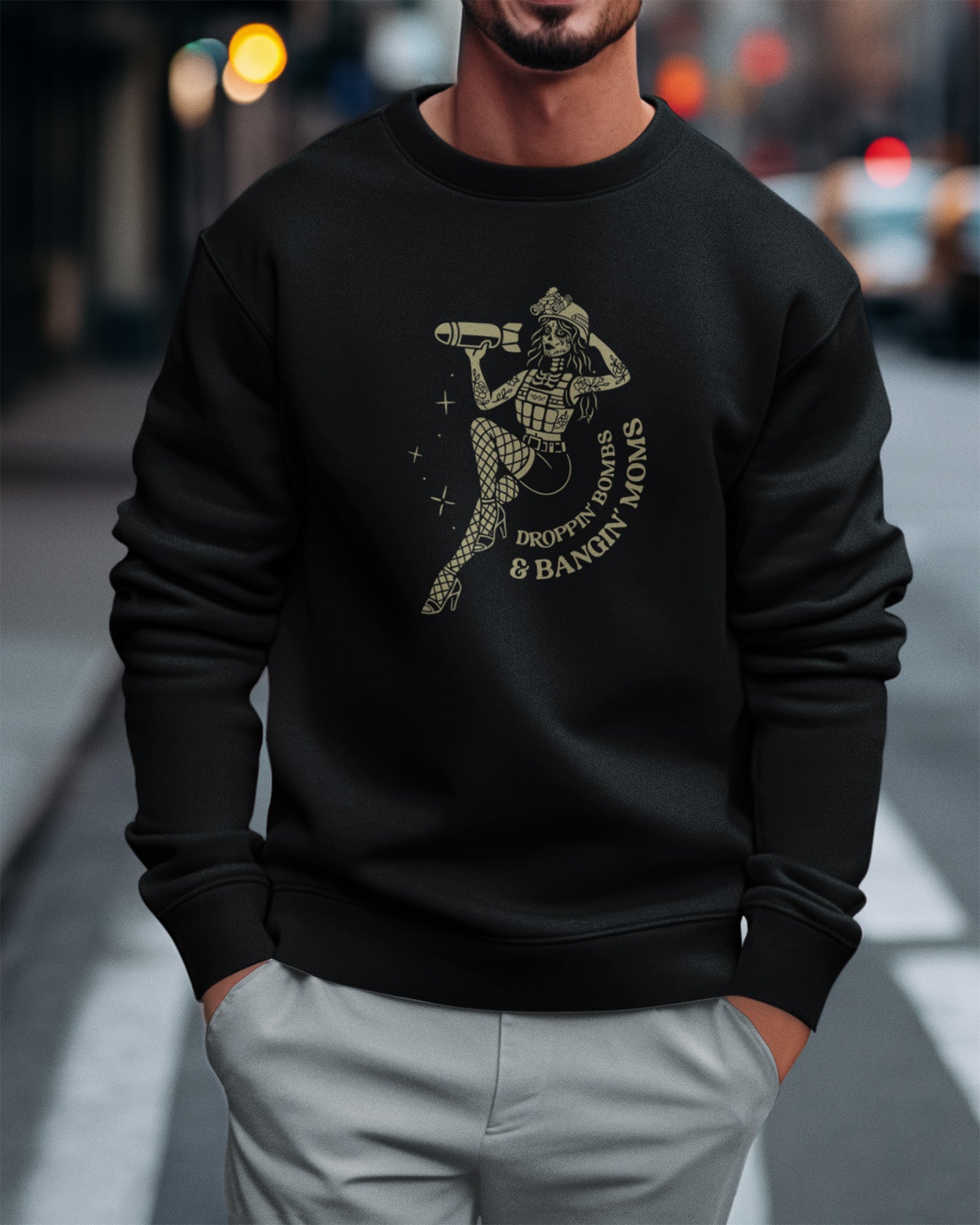 Person wearing a black sweatshirt with a graphic design on a city street.