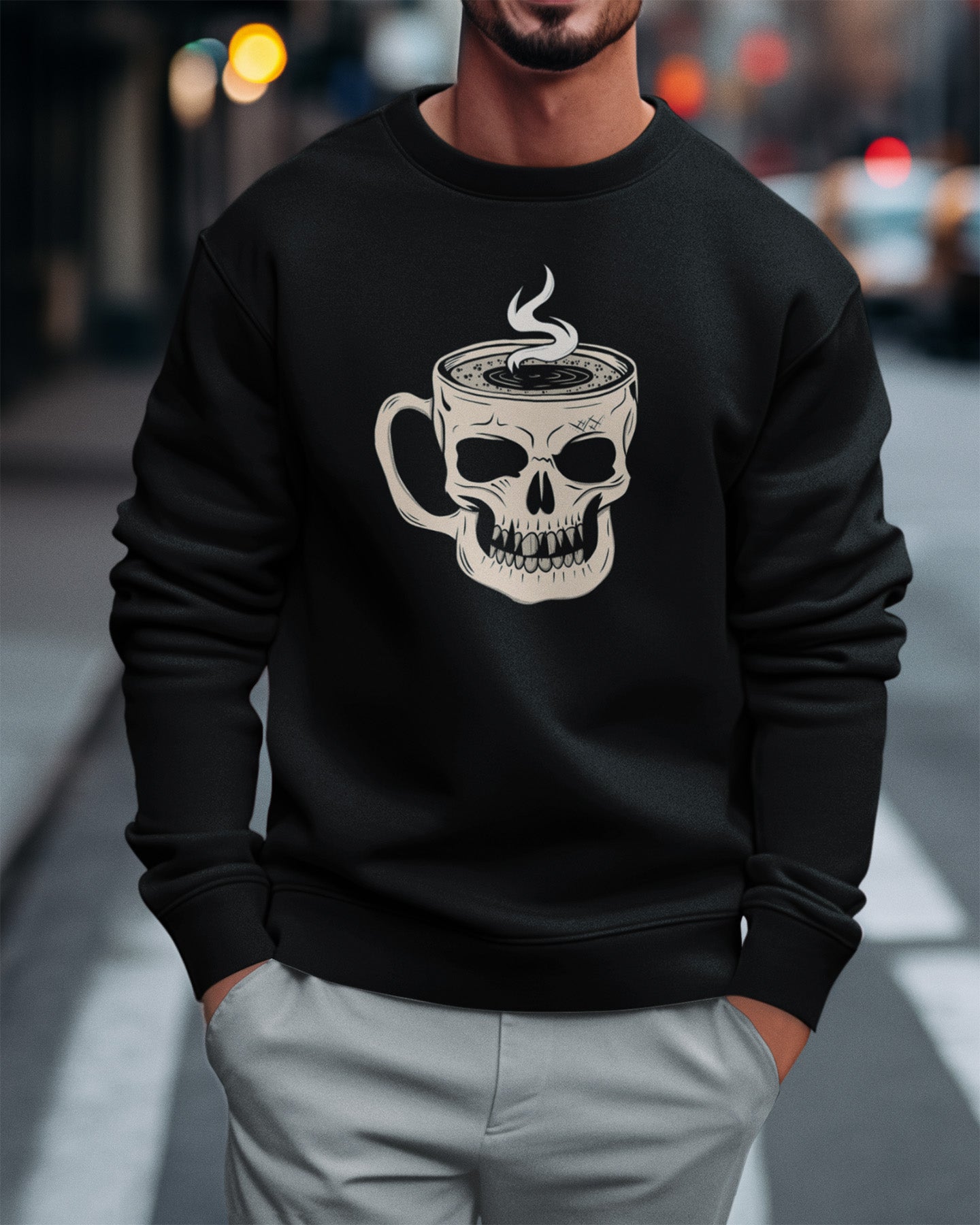Person wearing a black sweatshirt with a skull and coffee cup design on a city street.