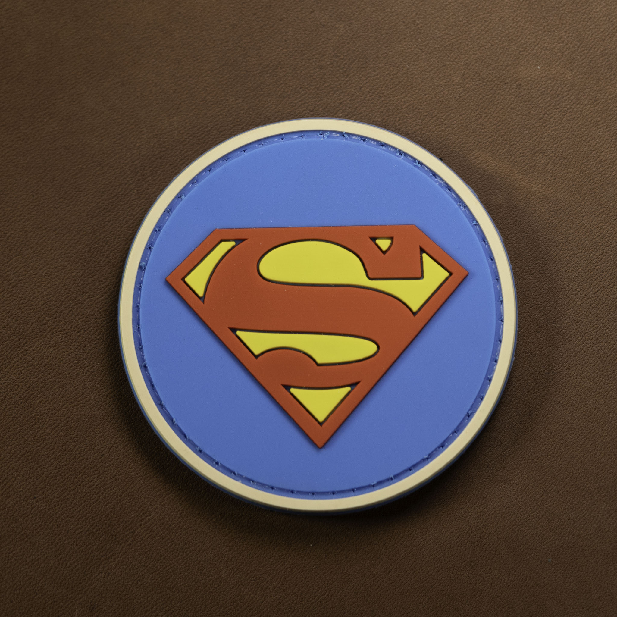 Round Superman PVC patch with red and yellow emblem on a blue background