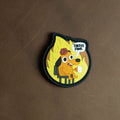 PVC patch depicting the ‘This Is Fine’ dog sitting calmly in a burning room with a speech bubble saying ‘This is fine,’ shown on a brown background