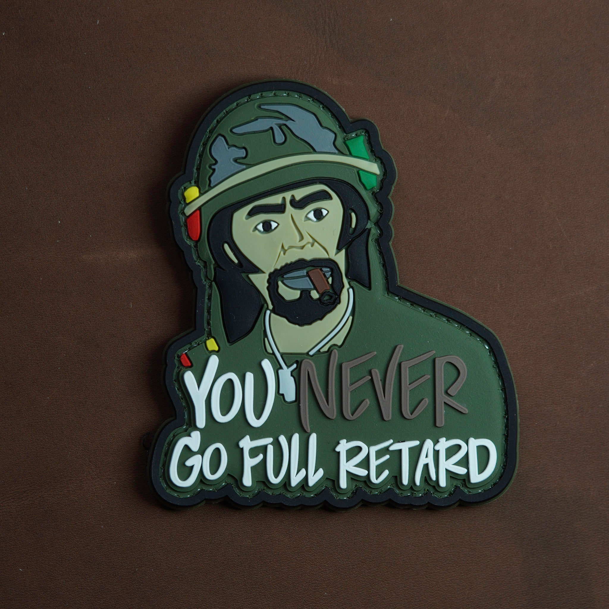 Patch with a character wearing a helmet and text 'You never go full retard' on a dark background