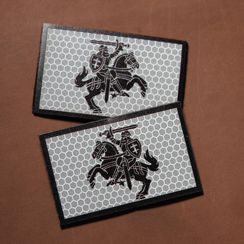 Two rectangular reflective patches featuring a black medieval knight on horseback over a hex-pattern silver background.